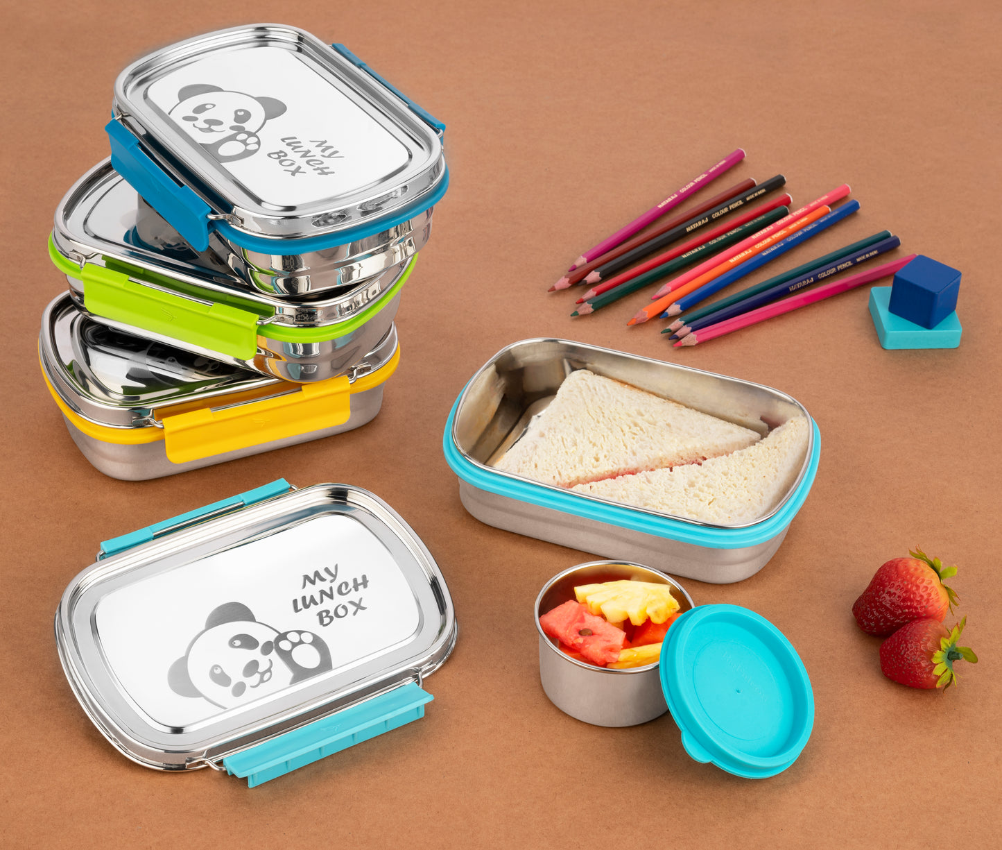 Munchy lunch boxes in different colors with colorful food items around stationary to depict ideal for school going children